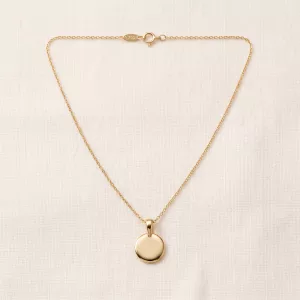 Soleil Medallion Necklace laid flat on linen: polished gold disc on a fine cable chain