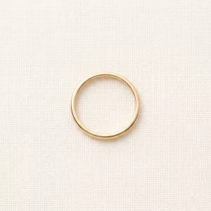 Slim polished gold band on linen