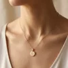 Soleil Medallion Necklace worn at the collarbone: a small polished gold disc on a fine chain